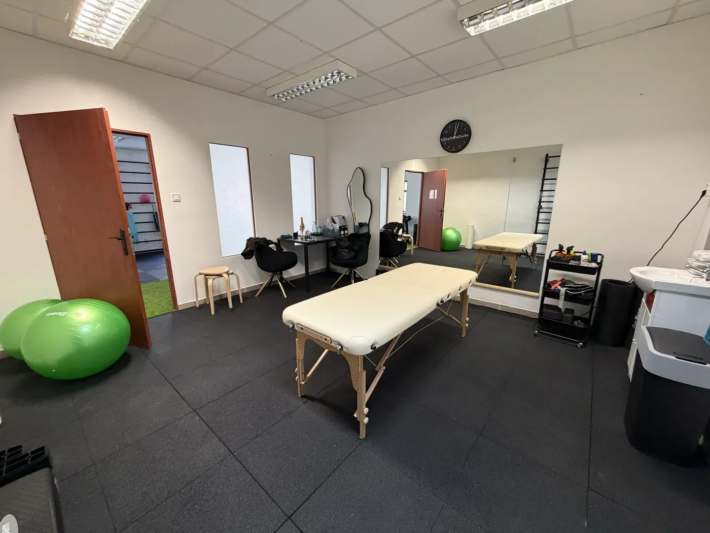 Treatment room with a mirror, a treatment table and exercise balls