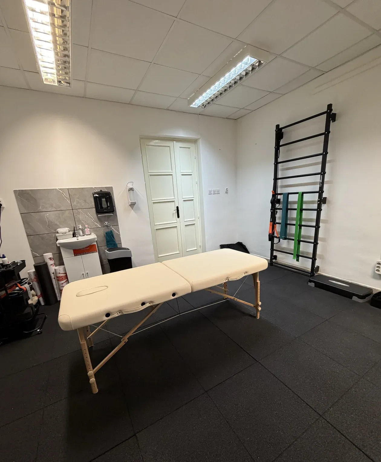 Treatment room at the Movement Club: treatment table, mirror, wall bars and an exercise ball